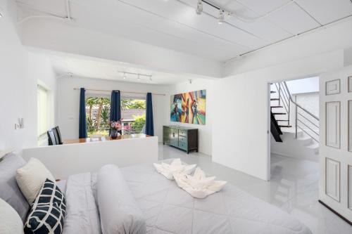 a white living room with a couch and a table at Chaweng Boho Modern in Ban Ko Khwan