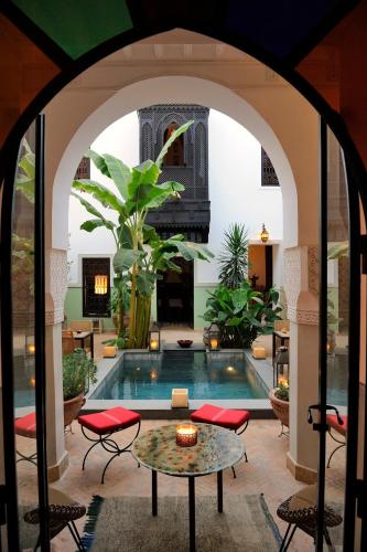 un arco che conduce a una piscina in una casa di Riad Azzar a Marrakech