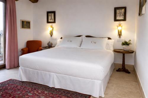 a bedroom with a large white bed and a chair at Casa Malinalco Hotel Boutique & Restaurante in Sotosalbos
