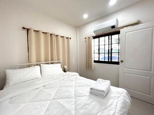 a bedroom with a white bed and a window at Airport Cozy House - Suvarnabhumi in Samutprakarn