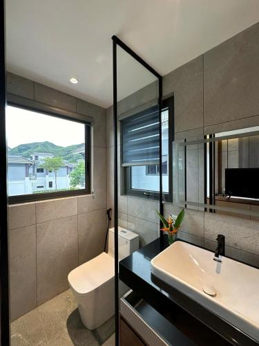 a bathroom with a sink and a toilet and a window at V3K05A Sonasea Vân Đồn in Quang Ninh
