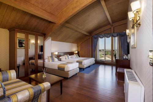 a large room with two beds and a couch at Best Western Classic Hotel in Reggio Emilia