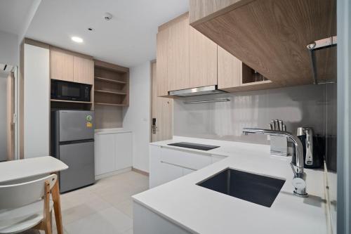 a kitchen with a sink and a refrigerator at Skypark Aurora in Laguna by Banyan Living in Thalang