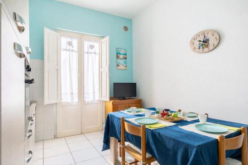 a dining room with a blue table and chairs at Terrazza Verdi-Roseto Vacanza in Roseto degli Abruzzi