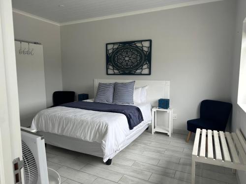 a bedroom with a bed and a blue chair at The Gallery in Franskraalstrand
