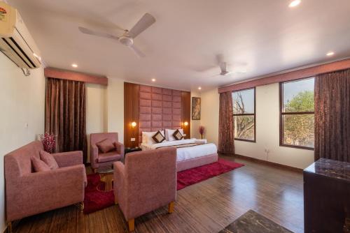 a bedroom with a bed and two chairs at La Comfort By shrpl in Gurgaon