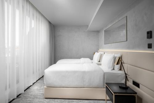 a bedroom with two white beds and a window at Clarion Congress Hotel Brno in Brno