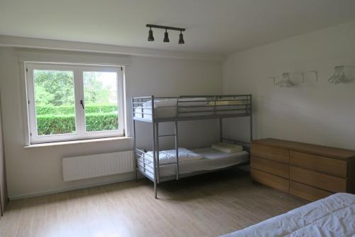 a bedroom with a bunk bed and a window at Villa Josiane in Oostduinkerke