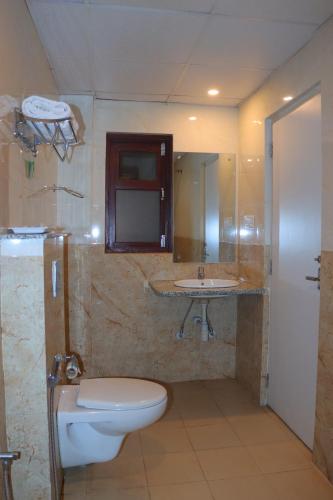 a bathroom with a toilet and a sink at Komal Hotel in Lālbhitti