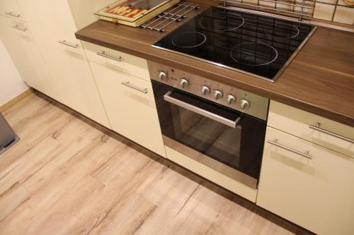 a kitchen with a stove and a wooden floor at Ferienwohnung Schmallenberg in Schmallenberg