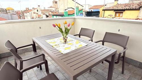 a table with a vase of flowers on a balcony at Iris Chioggia in Chioggia