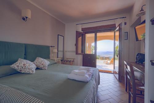 a bedroom with a green bed with a sliding glass door at Vitabella Toscana in Seggiano