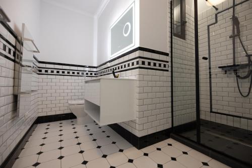 ein Badezimmer mit schwarz-weißen Fliesen und einer Toilette in der Unterkunft Opera Hotel in Timişoara