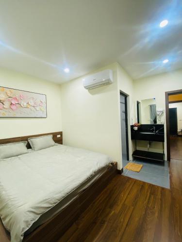 a bedroom with a bed and a dresser with a sink at CHIRU House Ninh Bình in Ninh Binh