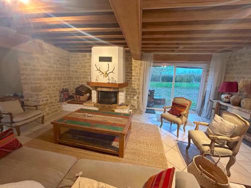 a living room with a table and a fireplace at Maison Saizy in Monceaux-le-Comte