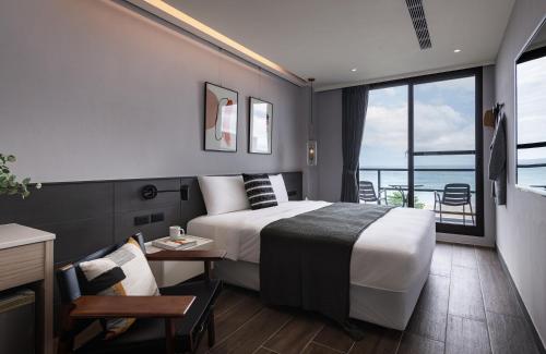una camera d'albergo con un letto e un balcone di Hido Hostel II a Kenting