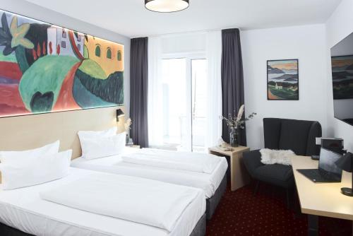 a hotel room with two beds and a desk at Altstadthotel Arte in Fulda