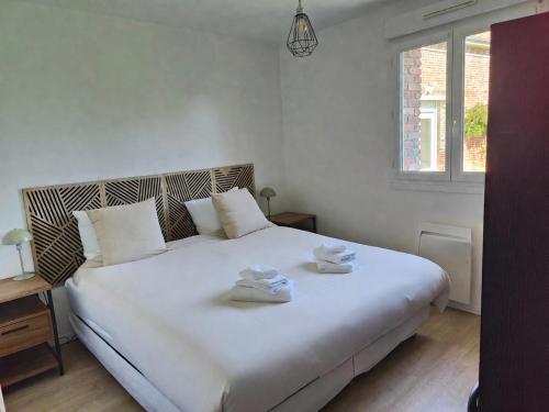 a bedroom with a large white bed with towels on it at La Clé des Vignes 1 in Roye