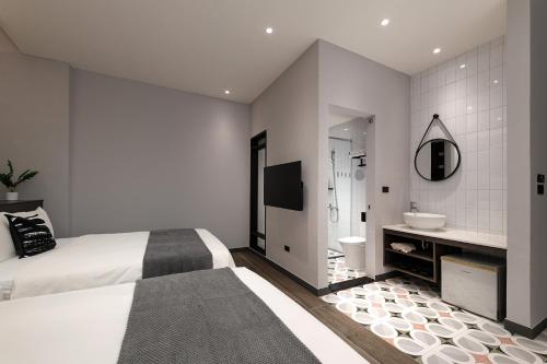 una camera da letto con un letto e un bagno con un lavandino di Hido Hostel II a Kenting