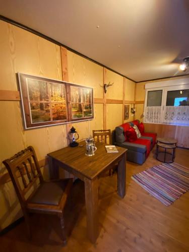 a living room with a wooden table and a couch at Wildhütte Schinderhannes in Schwarzerden