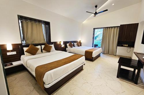 a hotel room with two beds and a window at Basil Leaf Resort in Varsoli