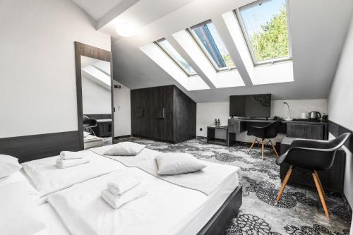 a bedroom with two beds and a desk in it at Hotel Zacisze in Węgierska Górka
