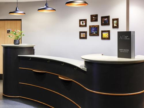 a reception desk in a room with pictures on the wall at ibis Hotel Northampton Centre in Northampton