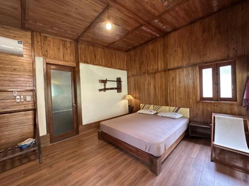 a bedroom with a bed in a wooden room at Laben Ecolodge in Na Dong