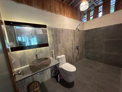 a bathroom with a toilet and a sink at Laben Ecolodge in Na Dong