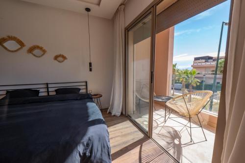 a bedroom with a bed and a balcony at Villa Palms de l'Atlas in Marrakesh