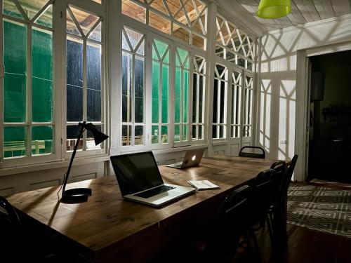 a laptop on a wooden table in a room with windows at Authentic house with a huge garden in Utsera