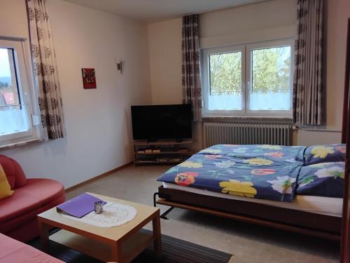 a living room with a bed and a tv at Ferienwohnung Kroeschell in Bad Sachsa