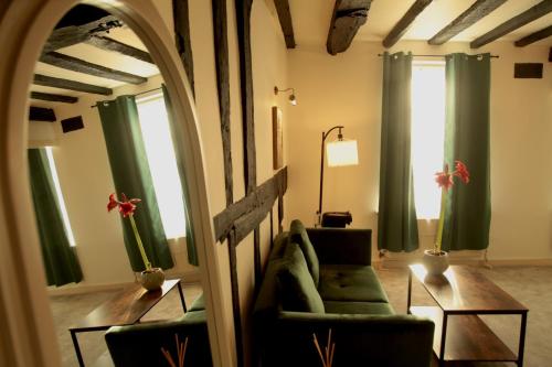 a living room with green chairs and a mirror at The Angel Posting House & Livery in Guildford