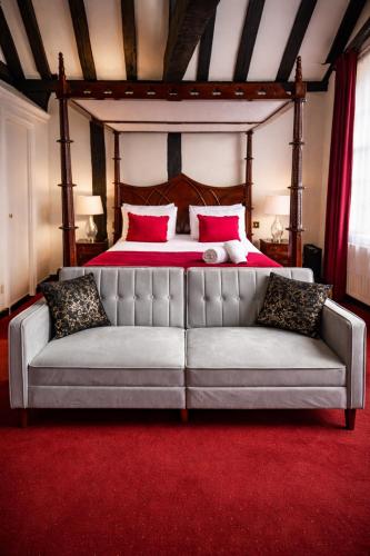a couch in front of a bed in a bedroom at The Angel Posting House & Livery in Guildford