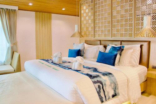 two beds in a hotel room with towels at Kacha Resort & Spa, Koh Chang in Ko Chang