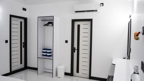 a white room with two doors and a shelf at Alyraa Sunset Mathiveri - Free Picnic Island Trip Included in Mathiveri