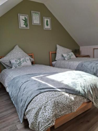 two beds sitting next to each other in a bedroom at Cottage en Saule in Port-Launay