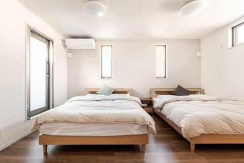 a room with three beds and two windows at yuanquanHOTEL in Osaka