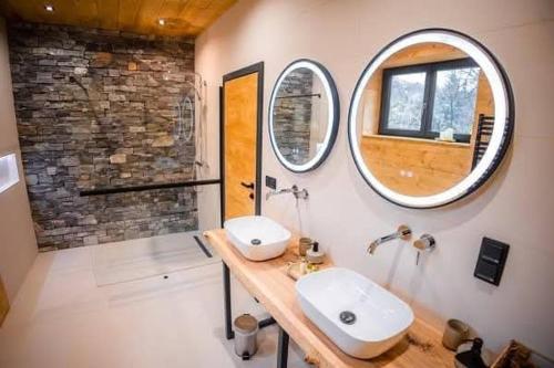 a bathroom with two sinks and a mirror at A Páholy - Grand Chalet Mátra in Mátraszentimre