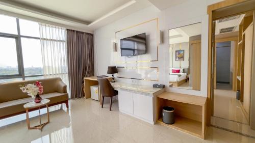 a hotel room with a bathroom with a sink and a couch at Elegant Airport Hotel in Bangkok
