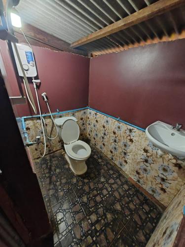 a dirty bathroom with a toilet and a sink at Happy Elephant Bungalows in Senmonorom