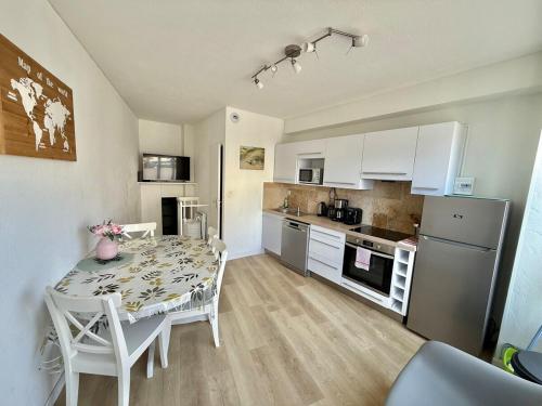 a kitchen with a table and a kitchen with white cabinets at Central Océan in Les Sables-d'Olonne