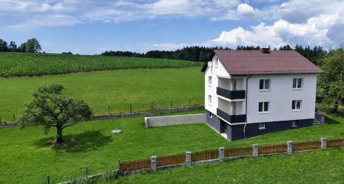a white house in a field with a tree at Mühlviertler Auszeit in Pisling