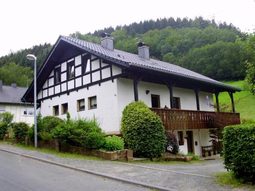 ein großes weißes Haus mit schwarzem Dach in der Unterkunft Ferienwohnung Schmallenberg in Schmallenberg
