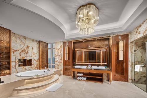 a bathroom with a tub and a sink and a chandelier at Crowne Plaza Taizhou by IHG in Taizhou