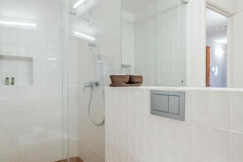 a white bathroom with a shower and a mirror at Flateli Santa Clara 31 in Girona