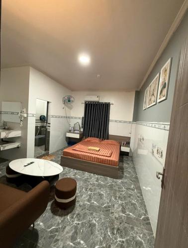 a bedroom with a bed and a table in it at Queen hotel in Cù Lao Nai