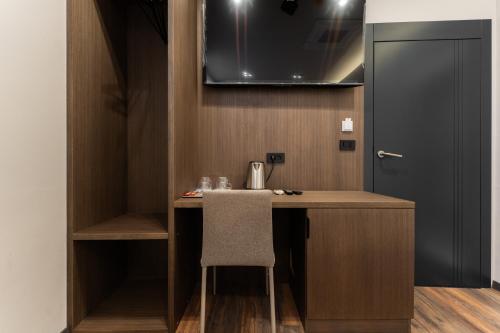 a small kitchen with a desk and a chair at Four Side Hotel in Prishtinë