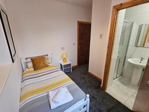 a small bedroom with a bed and a sink at Spacious 3-Bedroom House Near Leeds City Centre By Homebird Property Management Short Lets & Serviced Accommodation Leeds With En-Suite Bathrooms & Free Parking in Leeds