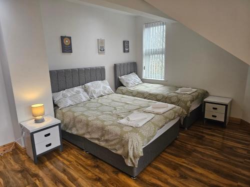a bedroom with two beds and a window at Spacious 3-Bedroom House Near Leeds City Centre By Homebird Property Management Short Lets & Serviced Accommodation Leeds With En-Suite Bathrooms & Free Parking in Leeds
